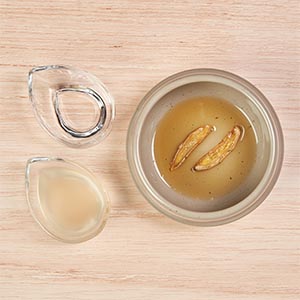 2. 鍋內加麻油炒香至捲曲，倒入桂冠麻油雞炒飯、一點米酒及雞高湯煮滾。