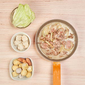 2. 豬肉起鍋備用，加入高麗菜及一風堂鹽味豚骨鍋底煮滾，最後放入花枝蝦漿以及百搭好料包中的火鍋料，煮滾後再將備用的豬肉放入鍋中。