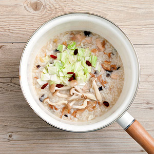 將冷凍的麻油雞炒飯一起入鍋中熬煮至濃稠，再依喜好加入米酒及鹽調味即可