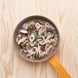 將豬肉以及中卷、香菇炒過後,再將洋蔥絲炒香後加入蛤蠣。