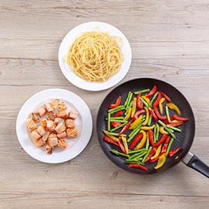 將義大利麵煮至喜歡的熟度;同時,熱油鍋後,將蒜片、鮭魚下鍋煎熟,鮭魚先起鍋