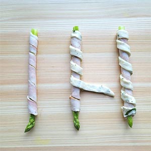 培根以斜捲方式捲蘆筍,再將蔥油餅條以同樣斜捲方式間隔約1.5公分捲在培根上