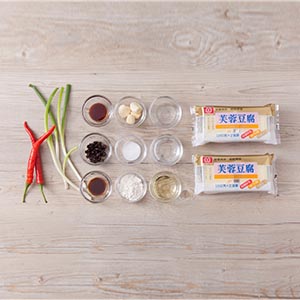 青蔥切成蔥白、蔥綠，辣椒和蒜頭切末，豆豉用米酒浸泡10分鐘。以紙巾吸乾芙蓉豆腐表面的水分，再切成塊，將豆腐塊均勻裹上一層薄薄的麵粉，備用。