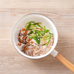 鍋內倒入少許油，依序放入蝦米、香菇絲、五花肉絲、蒜苗爆香。