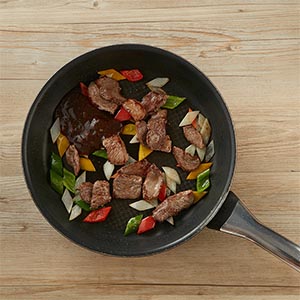 放入牛肉片炒至半熟,將黑胡椒醬入鍋中拌炒至牛肉熟即可。