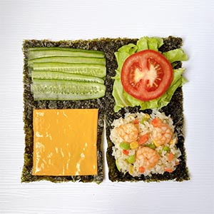 將海苔分成四區,依序放上起士片、小黃瓜、生菜+蕃茄片、桂冠蝦仁炒飯+淋上桂冠沙拉+柴魚片