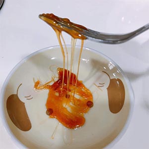 將沾好糖漿的湯圓放入盤中,趁剛才取出的糖漿尚未完全凝固前,拿一個叉子拔絲