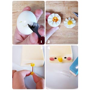 1. 水煮蛋用水果雕花器在上面插出一圈V型
2. 插一圈後即可剝開成鋸齒狀的兩半
3. 玉米粒兩顆插上煎過的麵條後,插在胡麻豆腐上如圖
4. 用打洞機壓海苔當眼睛,珍奶吸管壓火腿片當腮紅(食材有基本黏性,直接貼上即可)