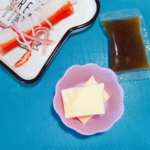 將蟳味棒燙熟放涼備用,芙蓉豆腐切小塊放在矽膠小菜盒內,放上撕開的蟳味棒絲,淋上內附的柴魚醬汁
