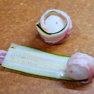 綠櫛瓜用水果皮刨刀削長薄片,放到豬五花肉片上,將飛魚蛋捲起,再用竹籤依序和甜椒串起