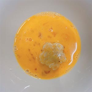 依序將飯糰沾裹蛋液