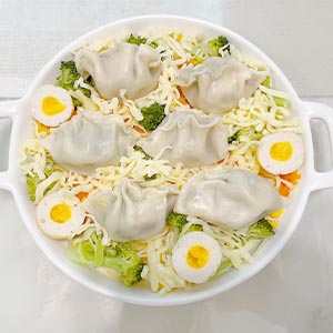 蒸熟後,焗烤盤底鋪上起司絲,擺上食蔬趁空隙倒入奶油培根醬,再撒上起司絲
最後放上水餃、入烤箱180度,約烤10分鐘(起司溶化即可)