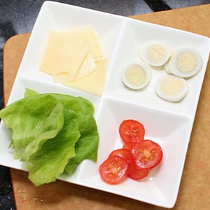 準備生菜、並將小蕃茄、鳥蛋跟起士片切成小片。