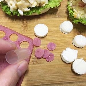 再以大吸管壓火腿片,沾一點沙拉醬黏貼在圓形饅頭耳朵上。