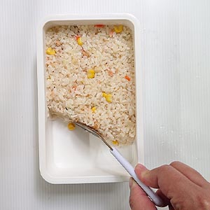 將微波好的桂冠鮭魚炒飯依圖示裝入便當盒中
小技巧:填裝時要注意!因為炒飯上面還會有裝飾,為避免搶了上頭裝飾的風采,所以盡量把好料藏在底下