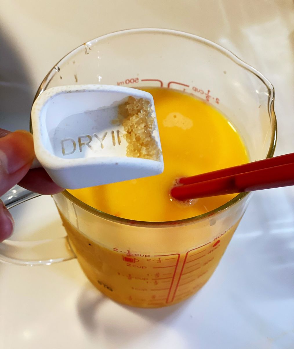 五顆蛋打散後,加入160ml高湯,再加入蟳味棒絲及明太子魚香腸丁拌勻。