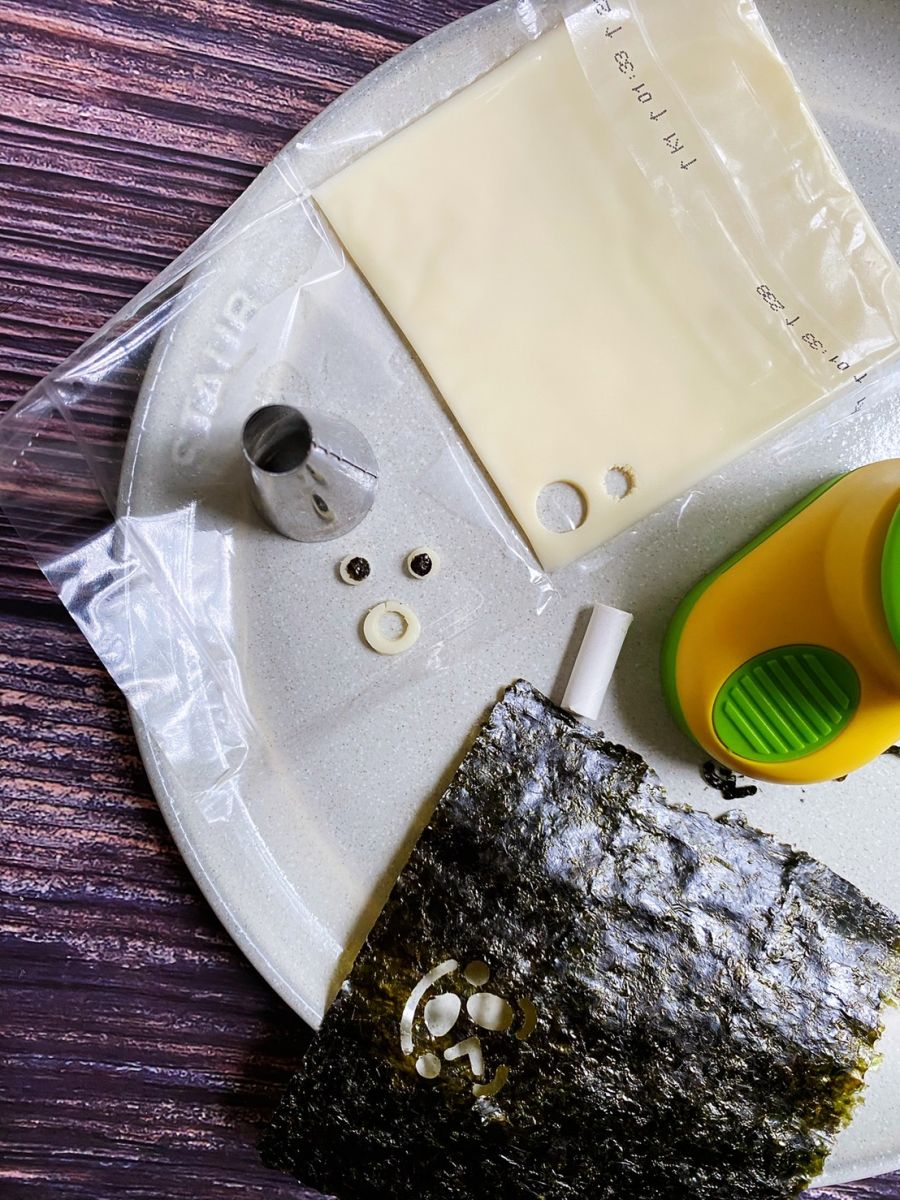 放入部隊鍋裡有略煮一下上色取出,用起司片壓出眼睛及嘴巴形狀