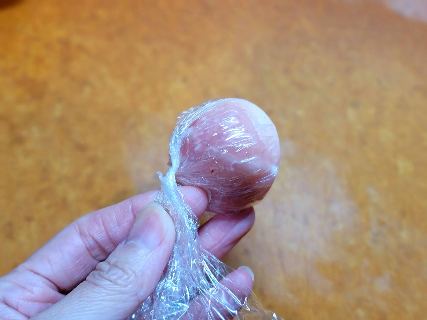 冷凍鮮肉湯圓用梅花肉片包起,用保鮮膜包覆捲緊,使肉片服貼。