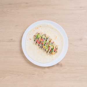 待墨西哥烤餅出爐後依序填入素三杯炒飯、蔬菜丁,擠上素沙拉,用烘焙紙捲成一捲即完成。