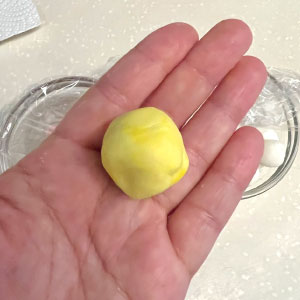 將退冰的白色小湯圓8顆捏碎，加入一點天然色粉或色素後重新捏成一個黃色湯圓麵團。